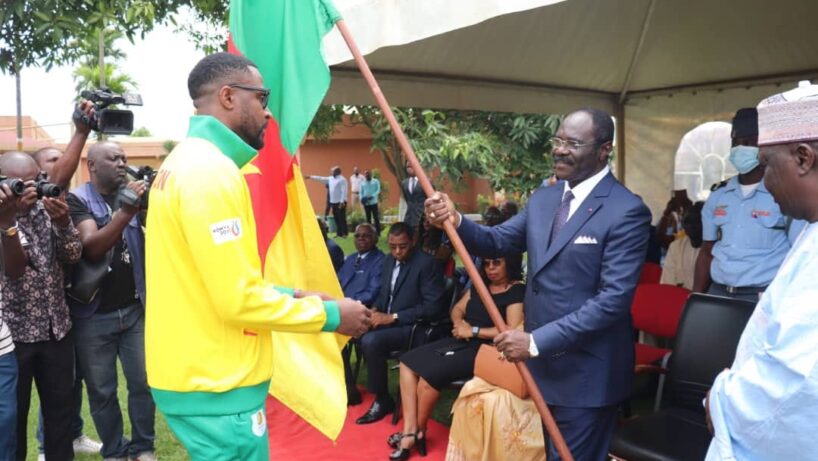 Le ministre des Sports camerounais remettant le drapeau au capitaine de la délégation